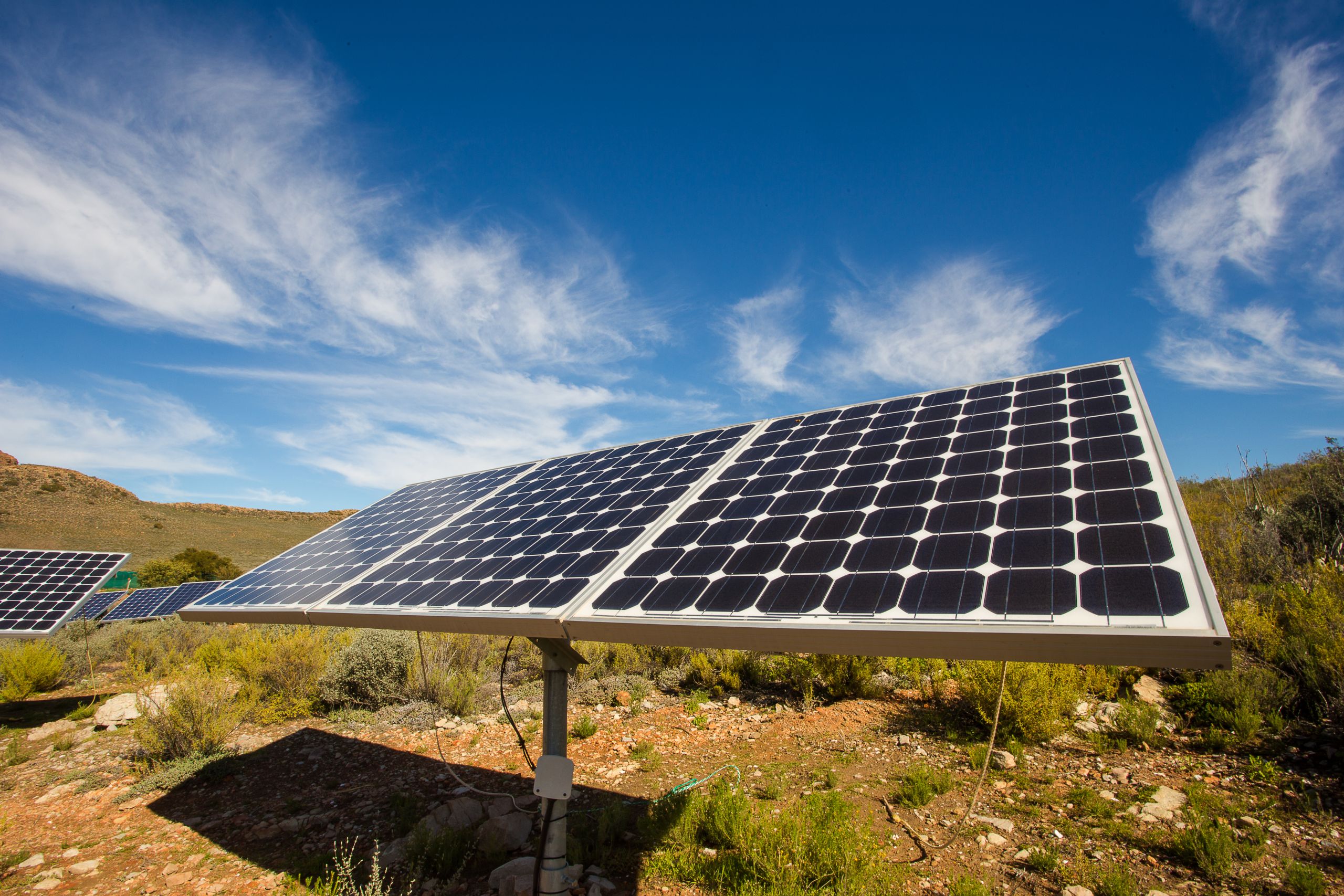 Close,Up,Wide,Angle,View,Of,Photovoltaic,Solar,Panels,On off grid solar panel with mountains